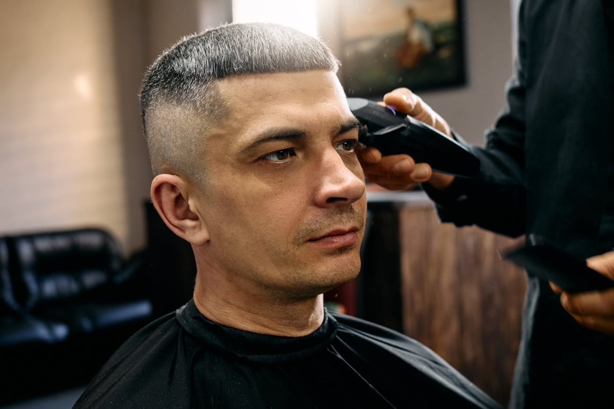 A skilled hairdresser is giving a man a fresh haircut in a contemporary barbershop.