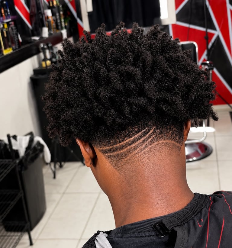 Back view of a person with textured black hair and a geometric fade design