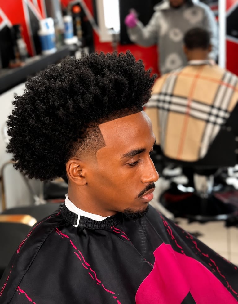 Man with textured black fade haircut and line designs